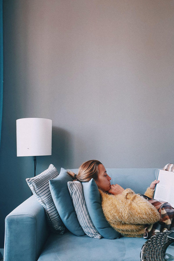 highly sensitive person reading book on blue couch