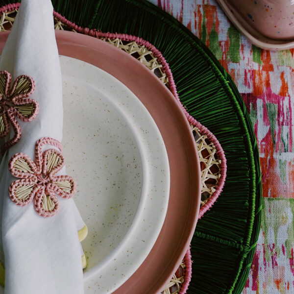 pink plate with green placemat and floral napkin rings colorful tablescape