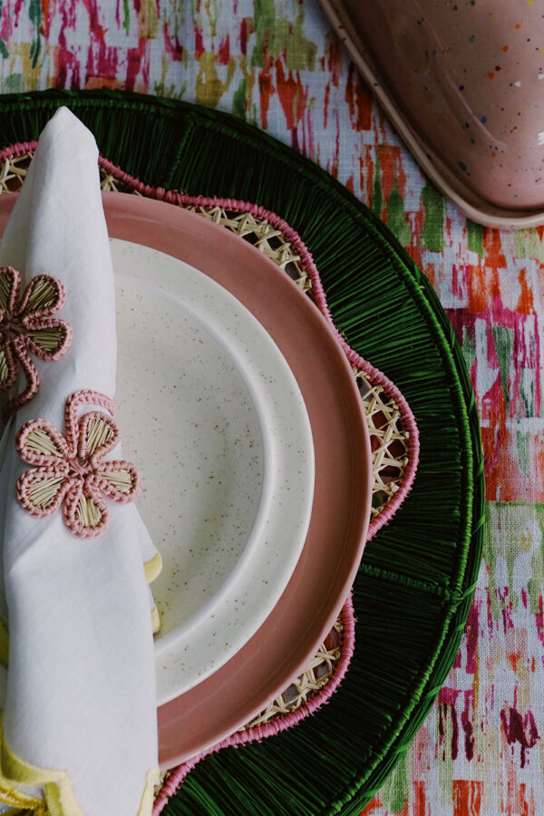 pink plate with green placemat and floral napkin rings colorful tablescape