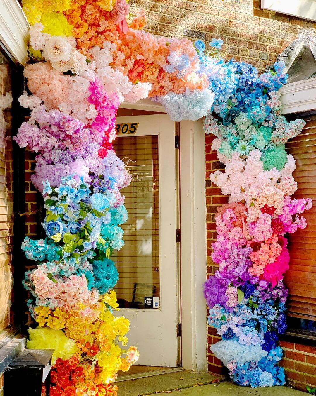 Rainbow faux floral doorway installation by Brightly Ever After