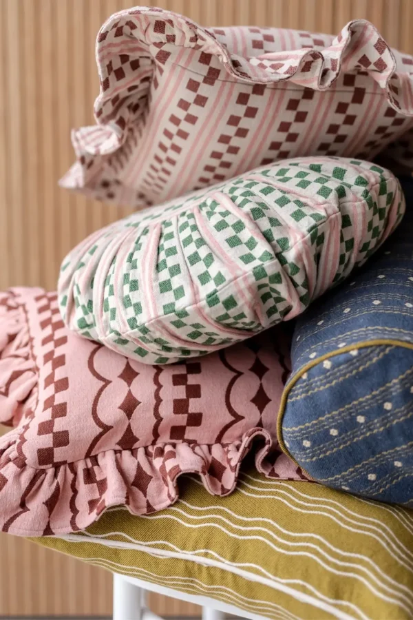 Stack of TBCO colorful decorative pillow covers in green and pink abstract patterns